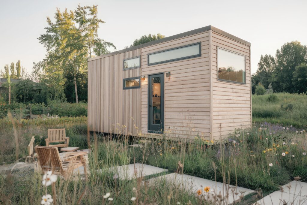 Une petite maison moderne qui inspire un mode de vie durable, en pleine nature, avec des chaises longues