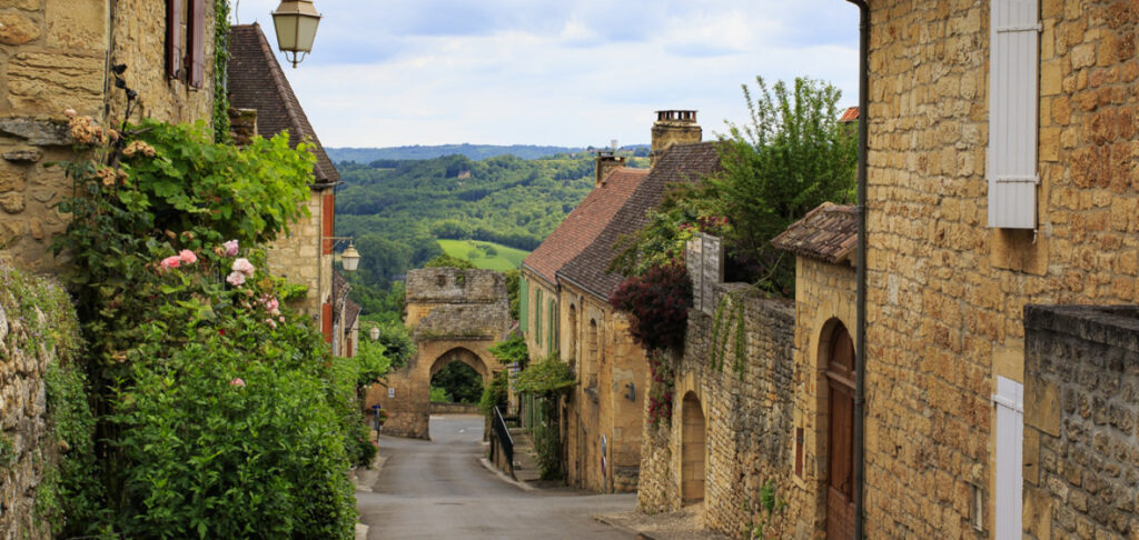 Rue de la traverse de Domme avec la porte de la combe